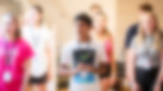 A group of young people in tee shirts stood with their mouths open as they learn vocal techniques.